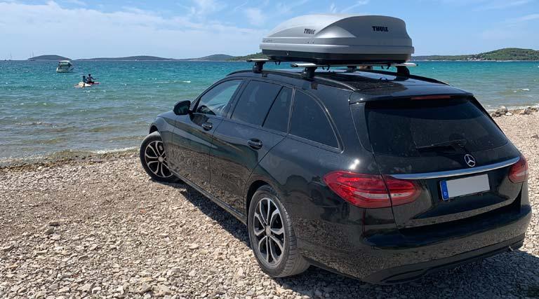 Mercedes-Kombi am kroatischen Strand mit Thule-Dachbox